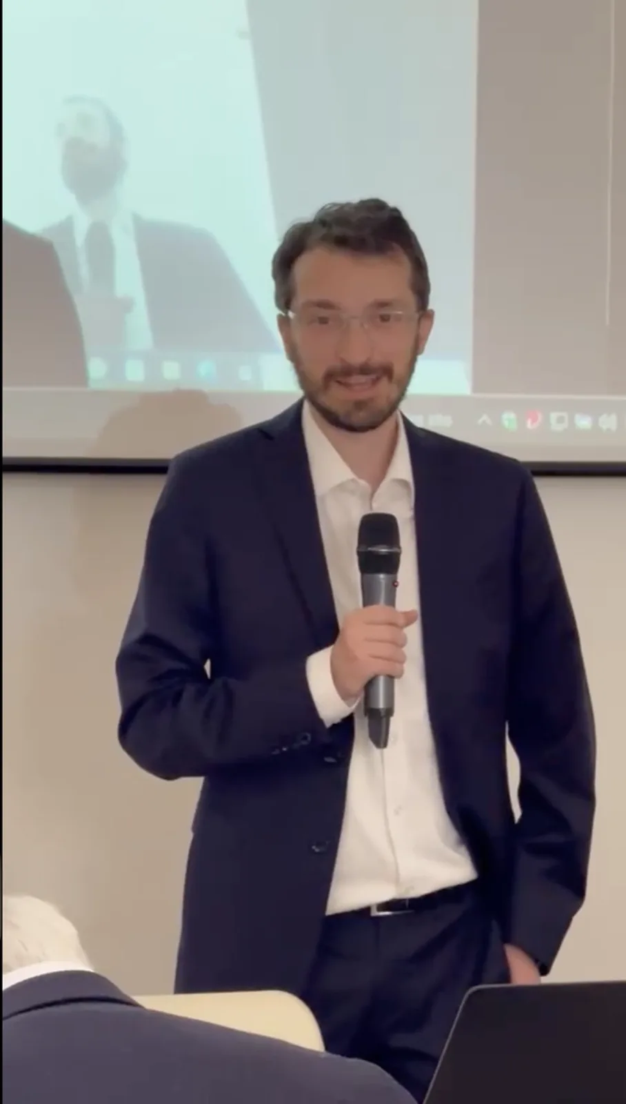 Speaker holding a microphone during the PolisMaker presentation event.